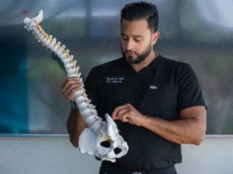 Dr. Raj Desai, pain physician, with a spine model